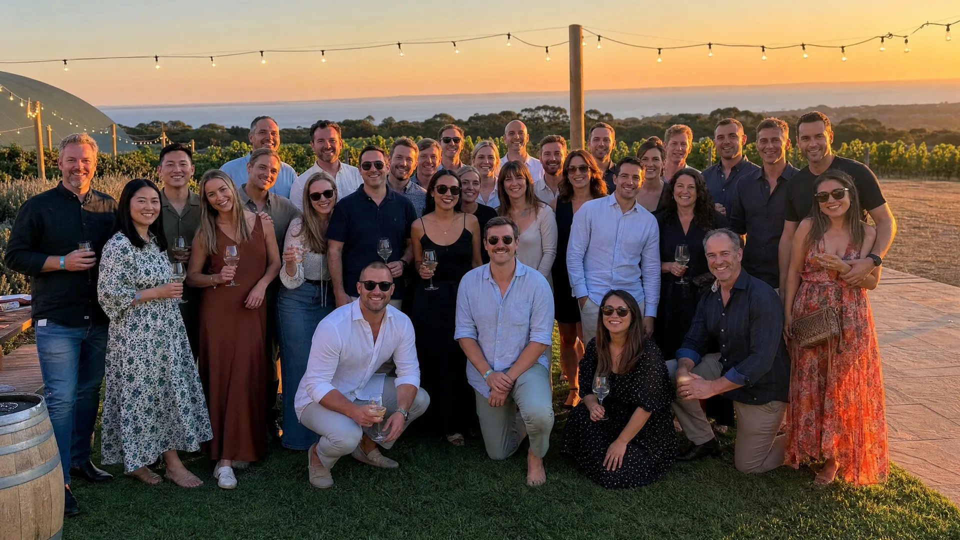 Team celebrating at a long outdoor dinner table at dusk